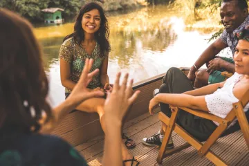 In a boat, a woman telling a compelling story to friends.